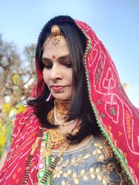 Portrait of young woman in traditional clothing against sky