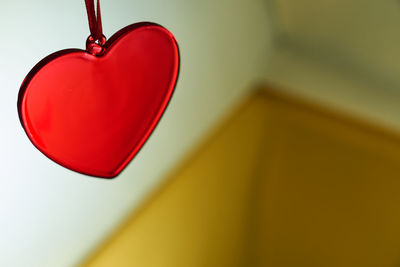 Close-up of red heart shape hanging on wall