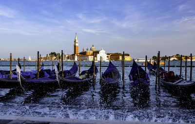 View of boats in canal against sky