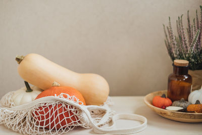 Autumn still life with pumpkins in and golden leaves on a wooden surface. autumn pumpkin