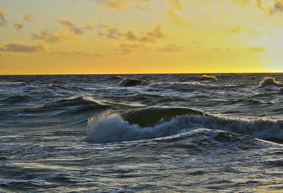 Scenic view of sea wave against sky during sunset