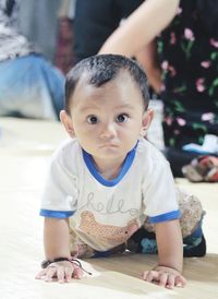 Portrait of cute boy on floor at home