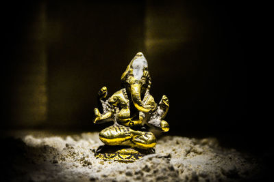 Close-up of buddha statue against black background