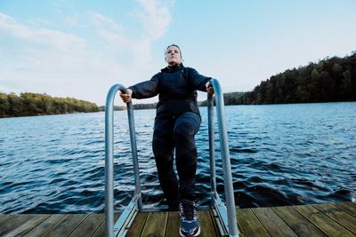 Portrait of man standing on lake against clear sky