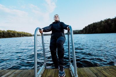 Portrait of man standing on lake against clear sky