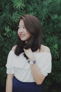 Smiling young woman standing in lawn