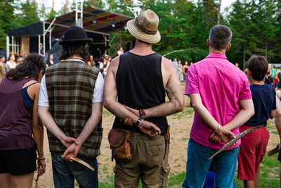 Rear view of people standing outdoors