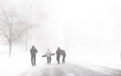 People walking on snow covered city in winter