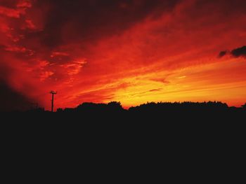 Silhouette landscape against orange sky