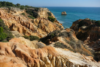 Scenic view of rocks in sea against sky