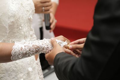 Midsection of bride holding wedding dress