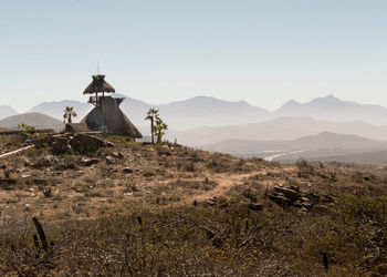 Down a long dirt road, a mexican hut restaurant poised on a cliff high above the pacific ocean