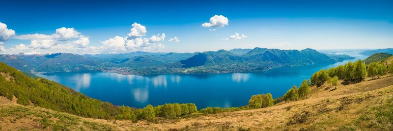 Panoramic view of lake and mountains against blue sky