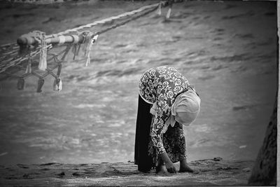 Rear view of woman working in water