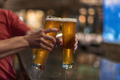 Close-up of hand holding beer glass