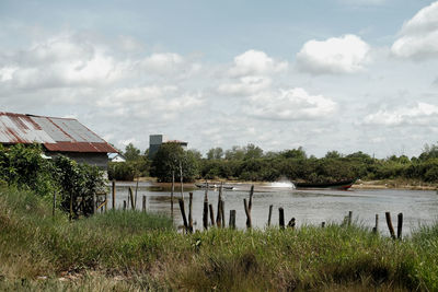 Houses by lake against sky