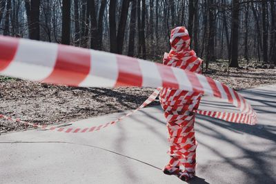 Person wrapped in signal tape on road