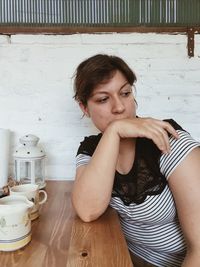 Portrait of young woman standing on table at home