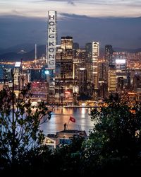 High angle view of illuminated city by river against sky