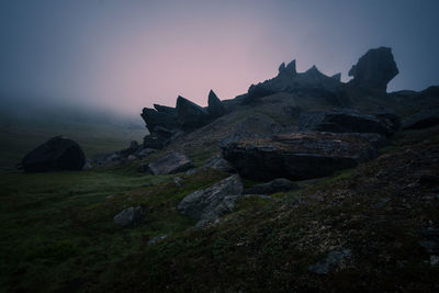 Rock formation on land against sky during sunset