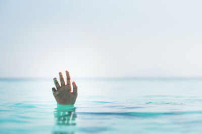 Person in sea against clear sky