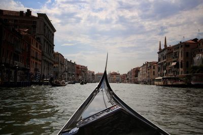 Canal amidst city against sky