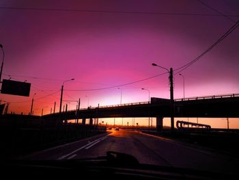 Cars on road against sky during sunset