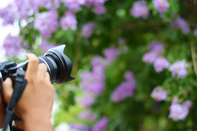 Midsection of person photographing camera