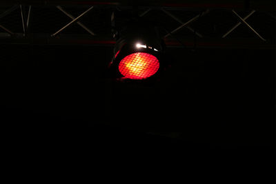 Low angle view of illuminated light bulb hanging from ceiling