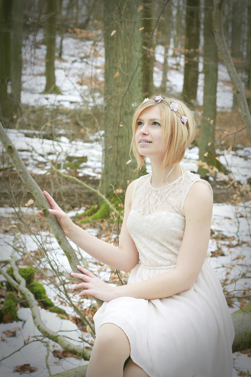 young adult, person, young women, lifestyles, leisure activity, casual clothing, tree, sitting, looking at camera, portrait, three quarter length, front view, waist up, smiling, standing, forest, focus on foreground