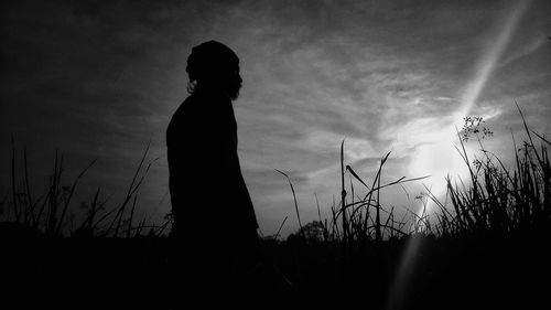 Silhouette woman standing on field against sky