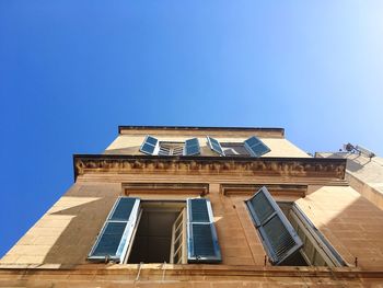 Low angle view of building against blue sky