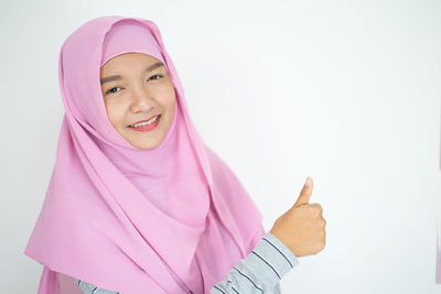 Portrait of smiling woman with pink hair against white background