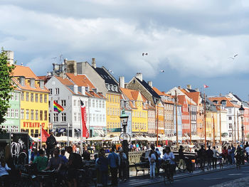 People on street in city against sky