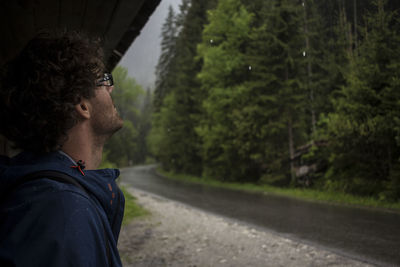 Man on road by trees