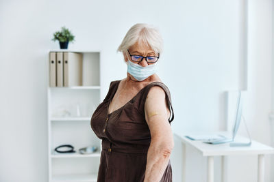 Portrait of woman standing against wall