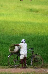 Man with bicycle on field