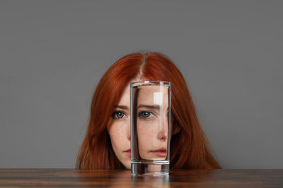 Portrait of young woman with eyes closed against black background