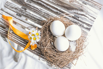 High angle view of eggs in nest by flowers on table