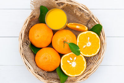 High angle view of orange fruits in basket on table