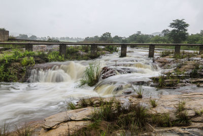 Scenic view of waterfall against sky