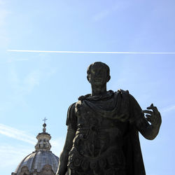 Low angle view of statue against blue sky during sunny day