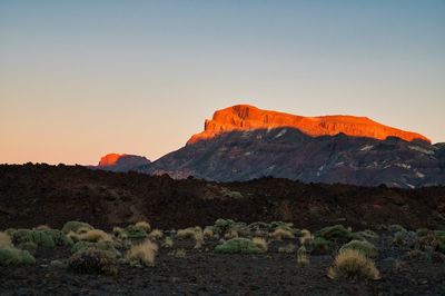 Scenic view of mountains against clear sky during sunset