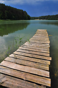 Wooden pier over lake against sky