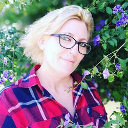 Close-up portrait of woman wearing sunglasses amidst purple flowers