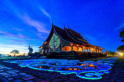 Illuminated temple building against blue sky