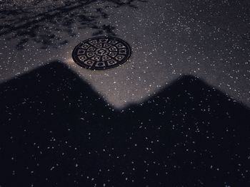 High angle view of manhole on street at night