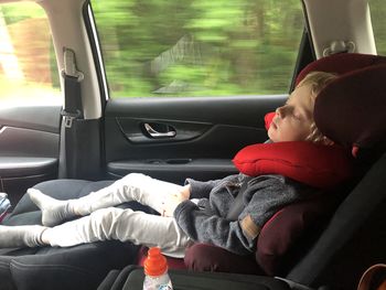 The baby sleeps in a child seat in the car