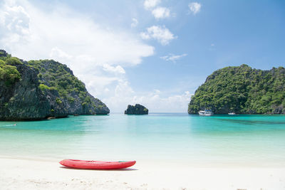 Scenic view of boat moored on shore at beach against sky