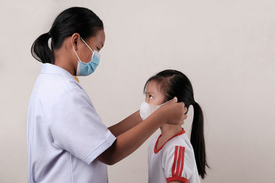 Rear view of two women standing in front of woman